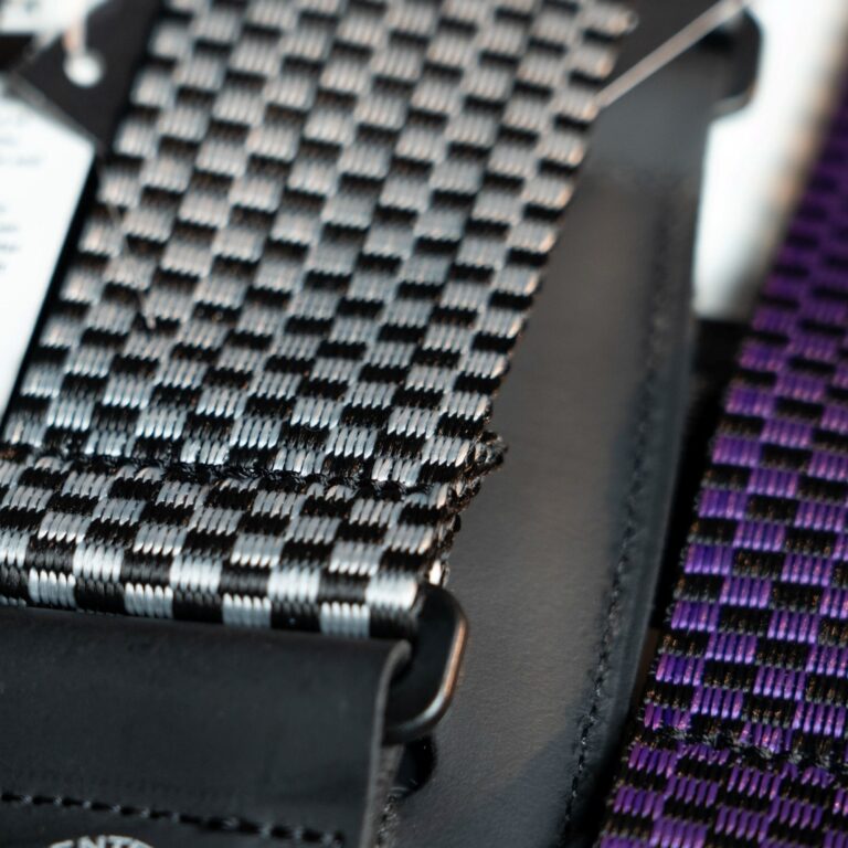 Close-up of a woven strap with black and white checker pattern and purple striped edge ขายราคาพิเศษ