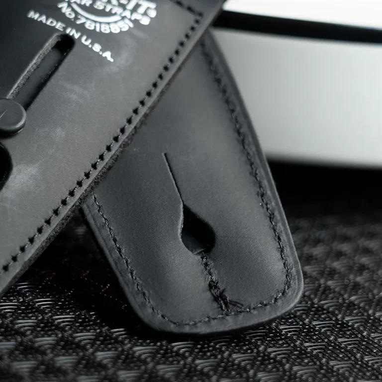Close-up of a black leather strap with stitching and a punched hole, showing detailed edge and texture. ขายราคาพิเศษ