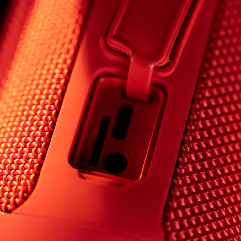 Close-up of a device's reset button and a small port, with the word 'Reset' visible on the housing under red lighting. ขายราคาพิเศษ