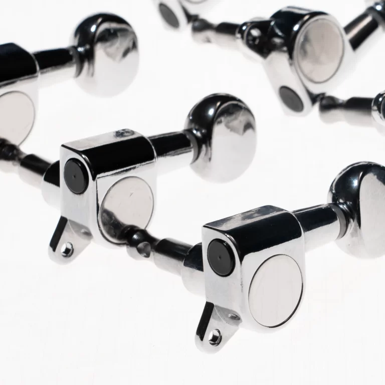 Close-up of polished chrome hinge joints with circular pivots, showing reflective metal components on a white surface ขายราคาพิเศษ