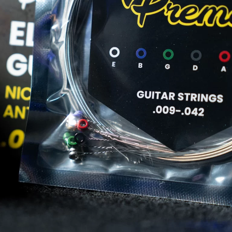 Pack of guitar strings in clear plastic with colored ball-end ferrules; label reads .009–.042 . ขายราคาพิเศษ