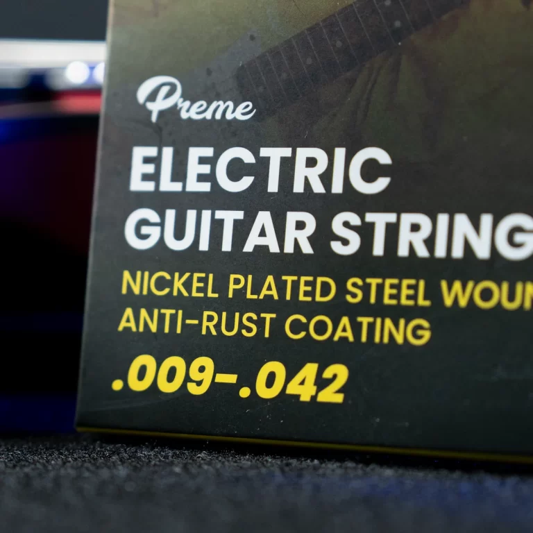 Package of electric guitar strings reading 'Electric Guitar Strings' with nickel-plated steel coating and gauge .009-.042. ขายราคาพิเศษ