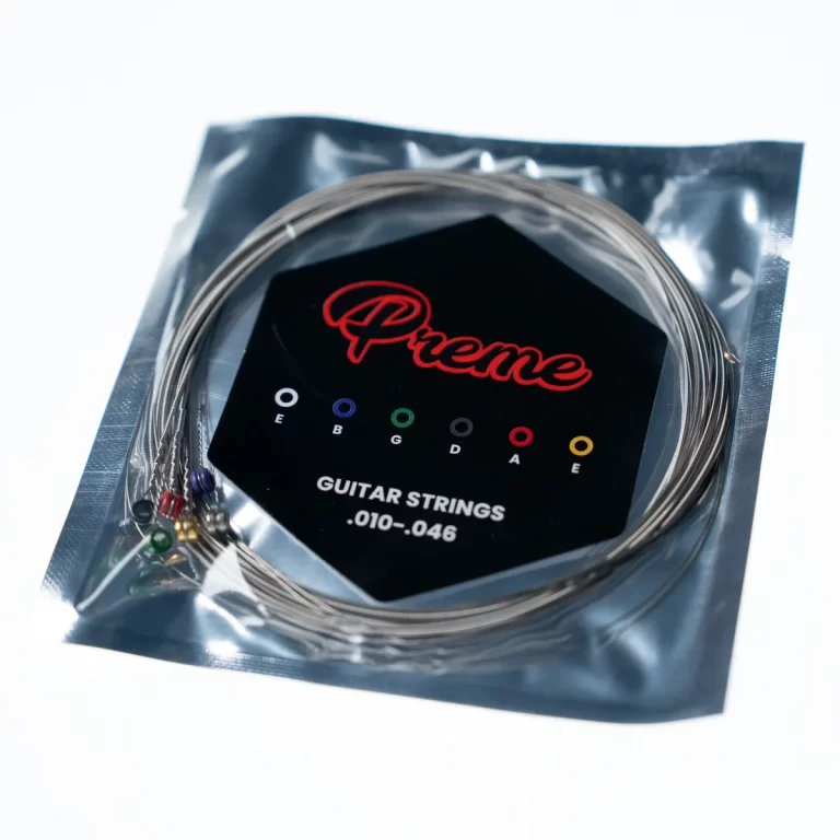 Guitar strings coiled inside a sealed pouch with a black card showing the red 'Prime' logo and tuning notes E A D G B E printed in colored circles ขายราคาพิเศษ