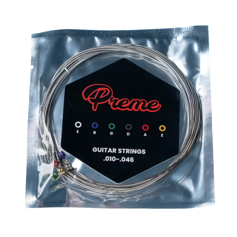 Coiled guitar strings in a sealed bag with a black label reading 'Prime' and 'GUITAR STRINGS .010-.046' with color-coded E–B–G–D–A–E dots on the label ขายราคาพิเศษ