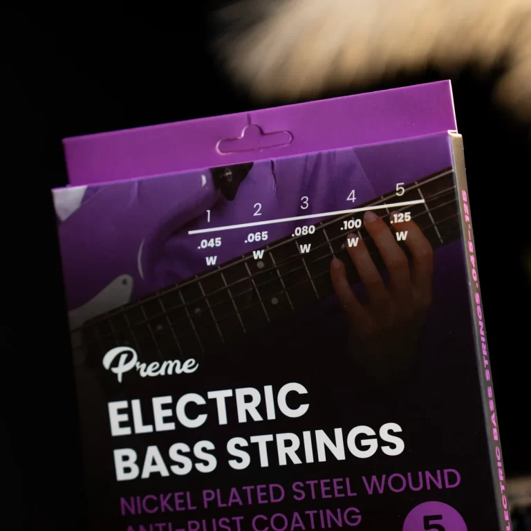 Box of Preme Electric Bass Strings with purple packaging; shows detailing of gauge numbers and a hand on a bass neck imagery in the corner. ขายราคาพิเศษ