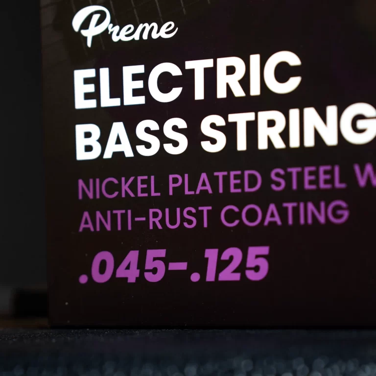 Close-up of a product label reading 'Electric Bass Strings' with nickel-plated steel and anti-rust coating, gauge .045–.125. ขายราคาพิเศษ