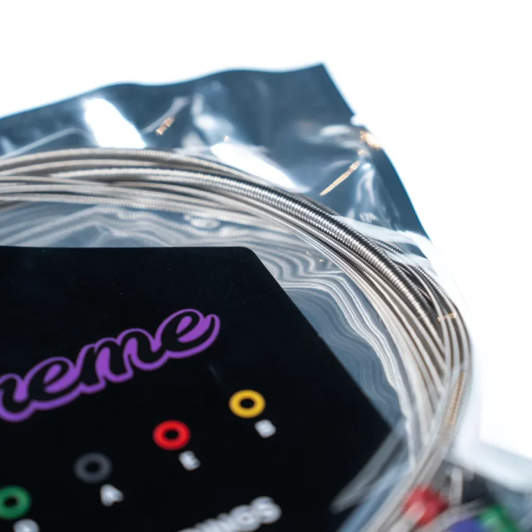Coiled silver beading wire in a clear plastic bag with a black label featuring purple script, a jewelry-making supply. ขายราคาพิเศษ
