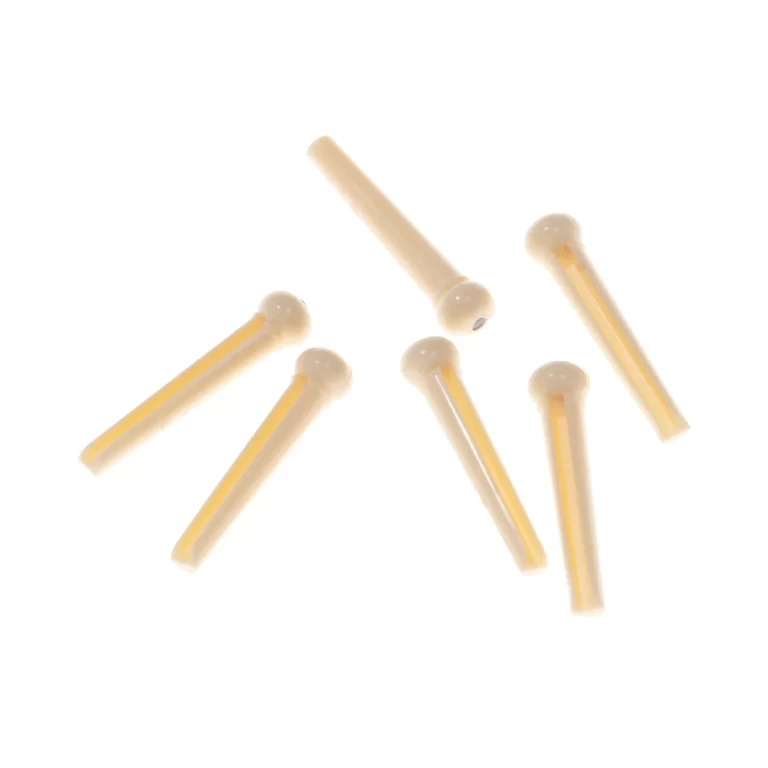 Several small beige plastic pins with rounded heads scattered on a white background. ขายราคาพิเศษ