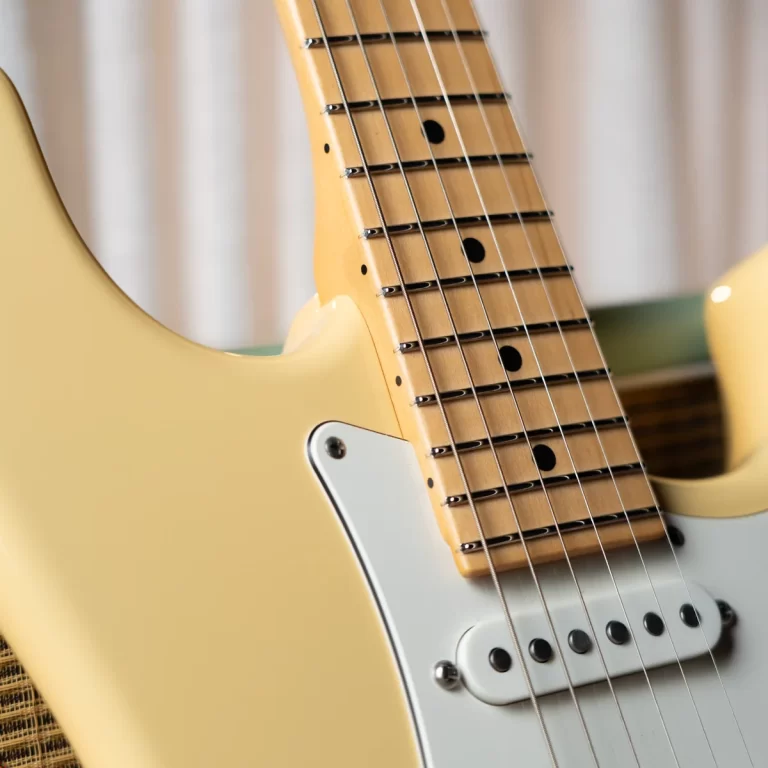 Close-up of a cream-colored electric guitar neck and strings, showing frets and a white pickguard with a single-coil pickup below the neck cap. ขายราคาพิเศษ