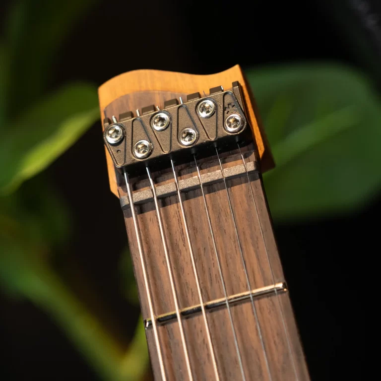 Close-up of a guitar headstock with tuning pegs and six strings visible on a wooden neck ขายราคาพิเศษ
