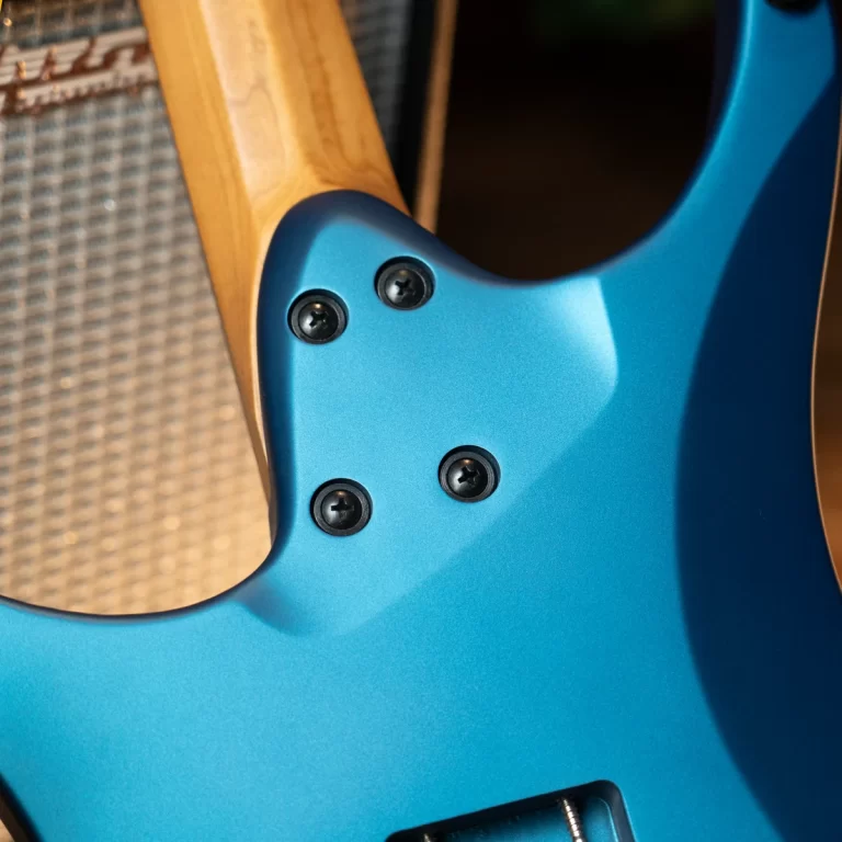 Blue guitar body with a maple neck bolted to the body using four screws; close-up of neck plate area. ขายราคาพิเศษ