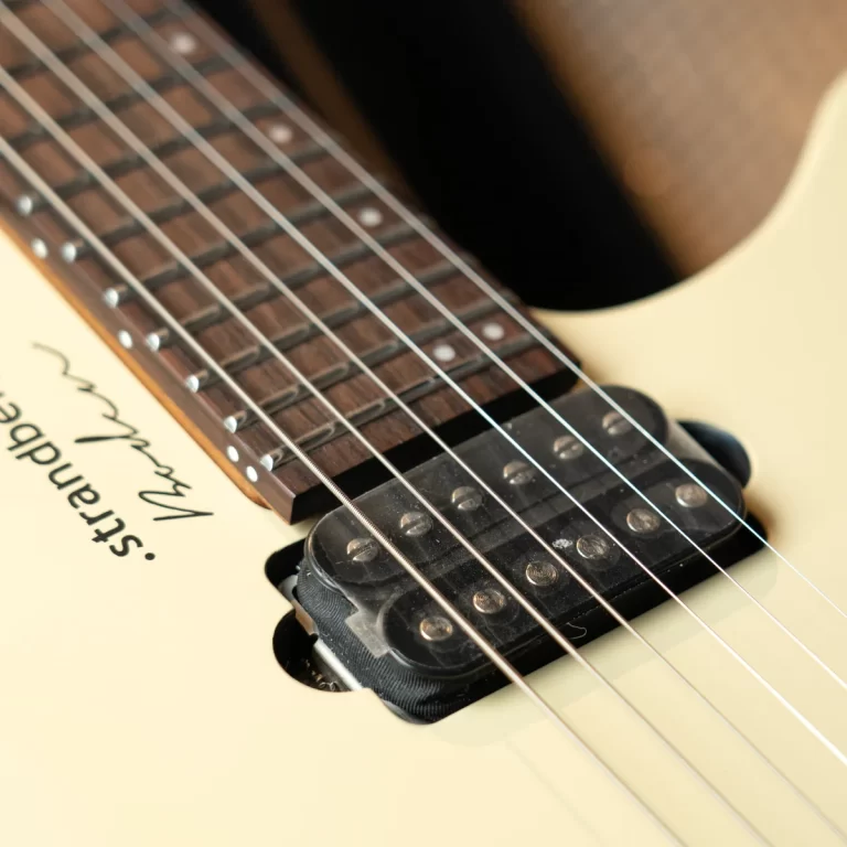 Close-up of a cream Fender Stratocaster neck with strings, fretboard, and pickup visible near the body. ขายราคาพิเศษ