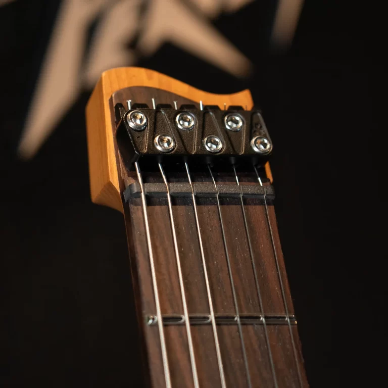 Close-up of a guitar headstock with locking tuners and six strings against a dark background. ขายราคาพิเศษ
