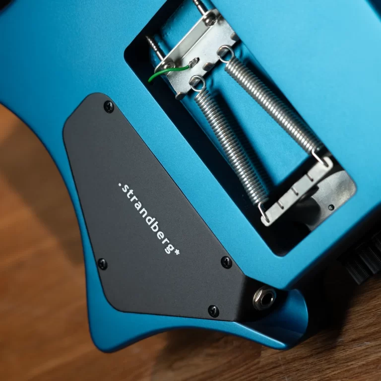 Close-up of the back of a blue Strandberg electric guitar showing the tremolo springs and bridge hardware in the cavity. ขายราคาพิเศษ