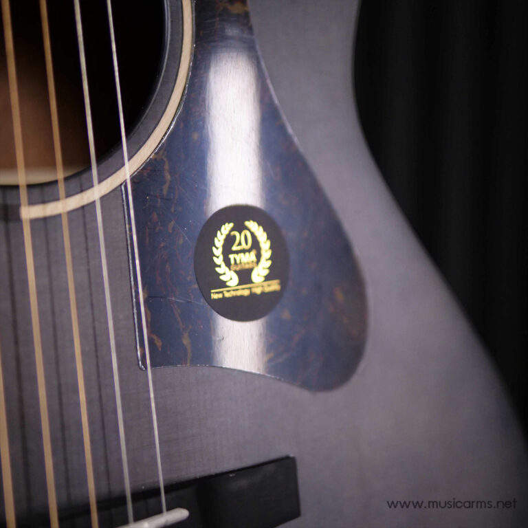 Close-up of a guitar body with a circular black badge featuring gold laurel and the text '20 TYMA'. ขายราคาพิเศษ